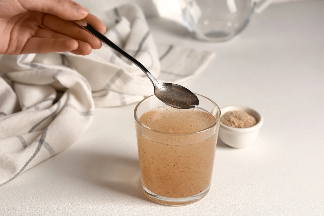 Flohsamenschalen in ein Glas Wasser rühren und quellen lassen. 