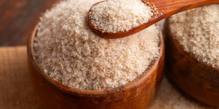 Flohsamenschalen in einer Schüssel und auf einem Holzlöffel