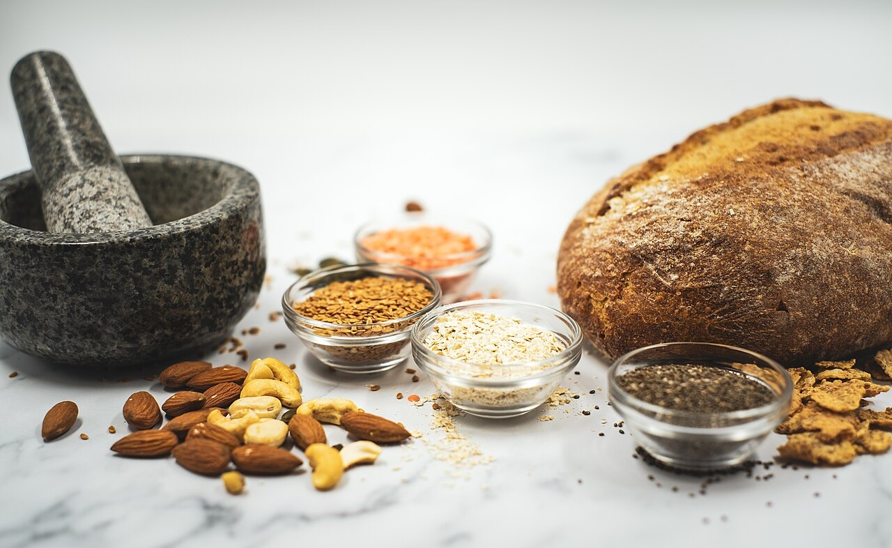 Ballaststoffreiche Lebensmittel wie Vollkornbrot, Nüsse, Haferflocken, Leinsamen und Linsen – ideal für eine gesunde Verdauung Nahrungsmittel-mit-viel-Ballaststoffen