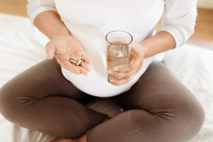 Bei einer Schwangerschaft kann in Absprache mit dem Arzt eine Vitamin-Supplementation sinnvoll sein Schwangere-Frau-nimmt-Supplemente