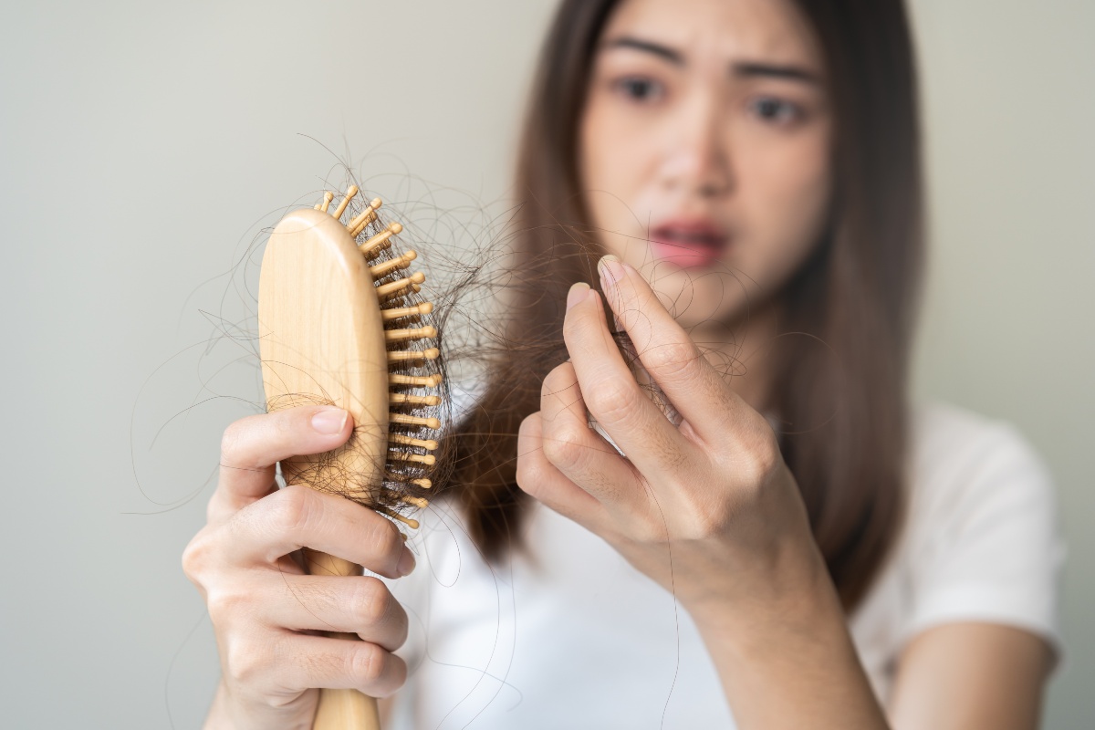 Zink unterstützt das Wachstum und die Regeneration von Haaren, Haut und Nägeln Frau-Bürste-Haarausfall
