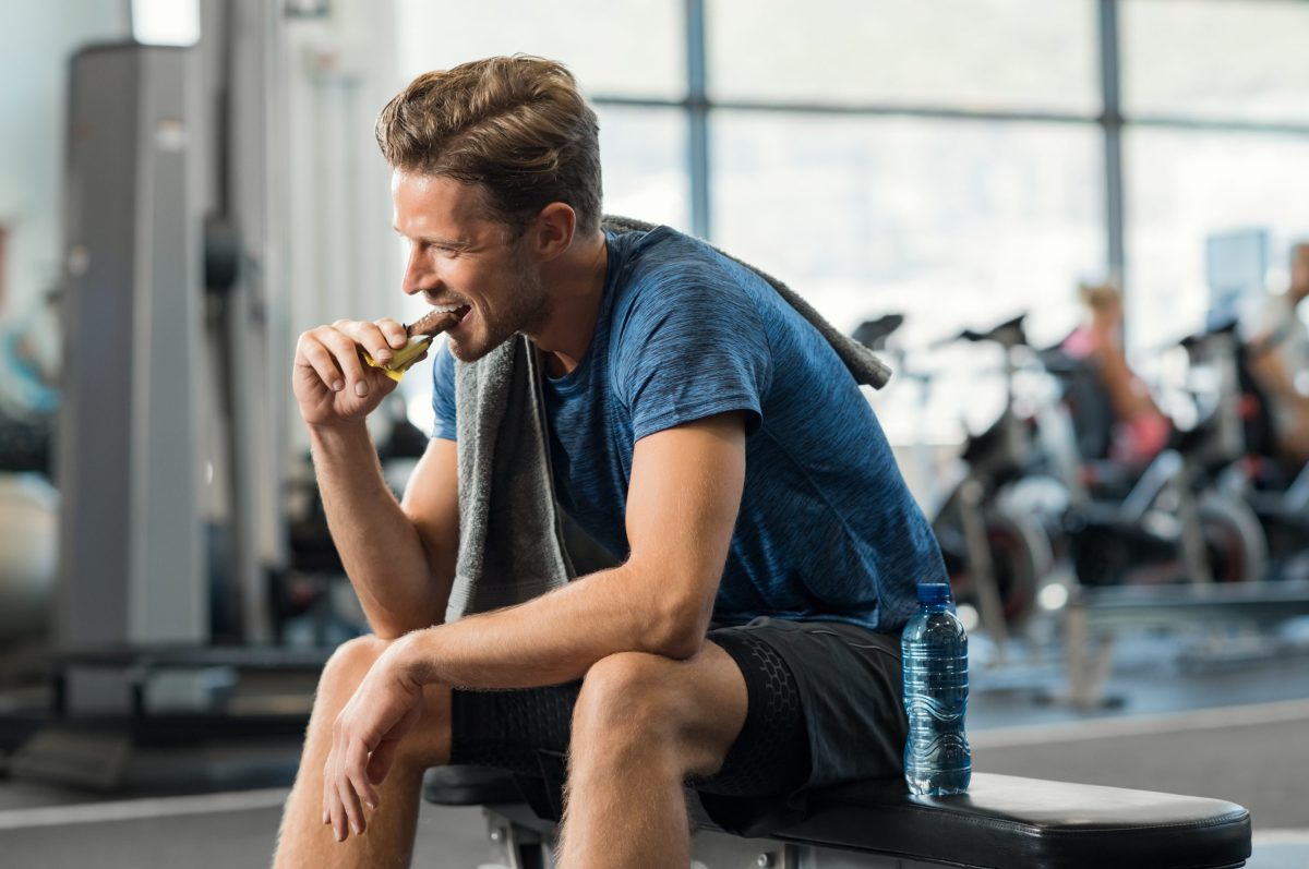 Eine gesunde Ernährung steigert das Leistungsvermögen – davon profitieren nicht nur, aber besonders Sportler Sportler isst Energieriegel