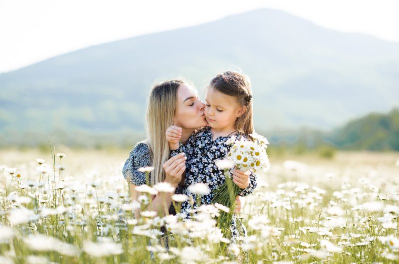 Mutter-mit-Tochter-in-einem-Feld-voll-Mutterkraut