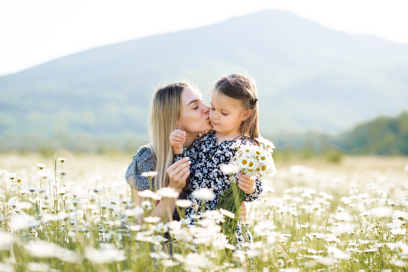 Mutter-mit-Tochter-in-einem-Feld-voll-Mutterkraut